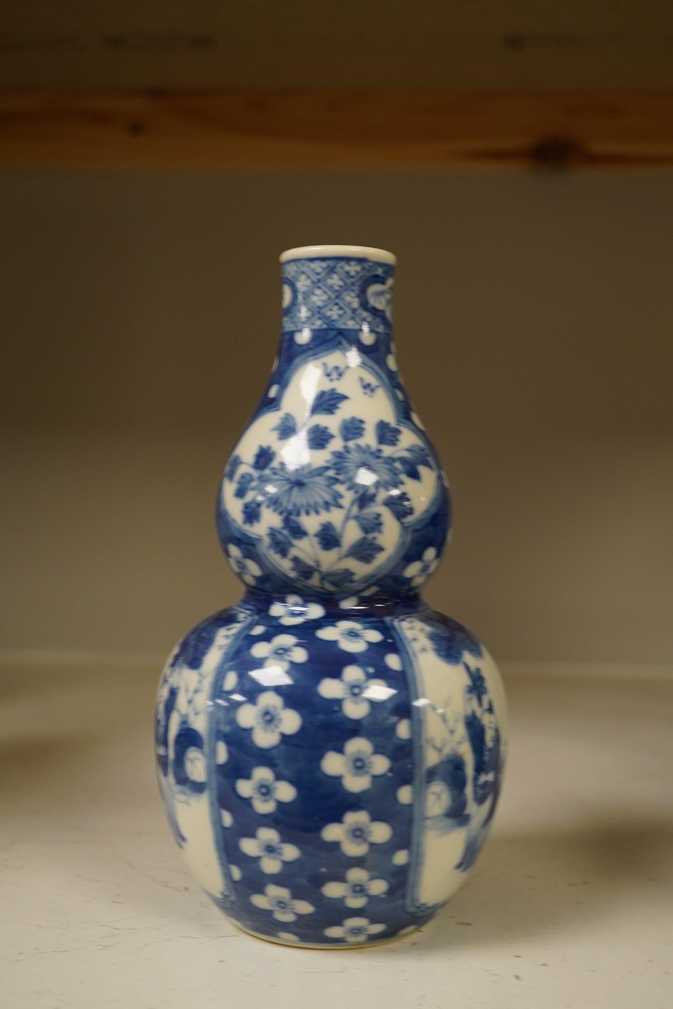 Two Chinese vases; a blue and white double gourd vase and famille noir vase, famille noir 19cm high. Condition - good